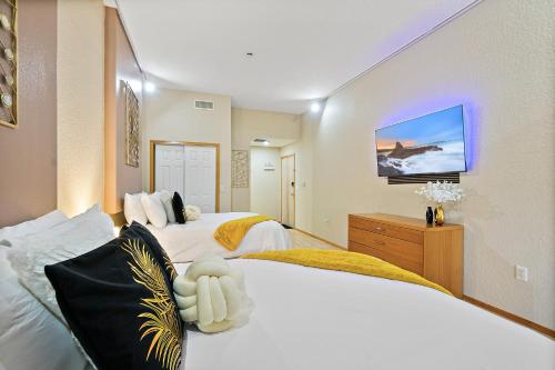 棕榈海岸European style Queen Suite in Palm Coast - Best view with Balcony near Beaches!的一间卧室设有两张床,墙上配有电视。