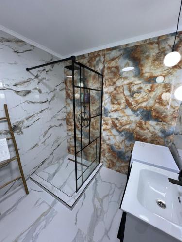 比斯特里察EightApartament的一间带水槽和大理石墙的浴室
