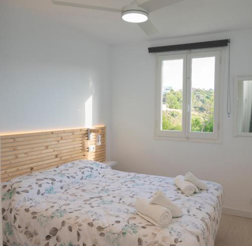 阿雷纳尔登卡斯特尔Apartamento Sol Isla Arenal de'n Castell的一间卧室配有一张床,上面有两条毛巾