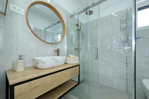 多布罗波尔贾纳Orchid Stay的浴室配有盥洗盆和带镜子的淋浴