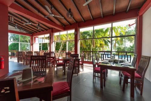 呼拉Silver Oasis Maldives的餐厅设有桌椅和大窗户。