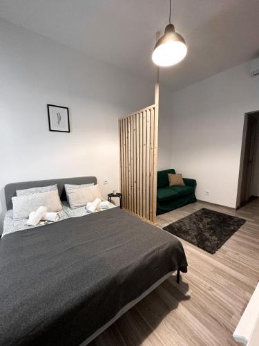 布达佩斯Dolce Vita Budapest的一间卧室配有一张大床和一张绿色沙发