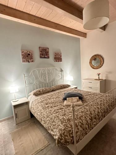 基亚拉瓦莱Affittacamere Il Cortile的一间卧室配有一张带金属床架的床