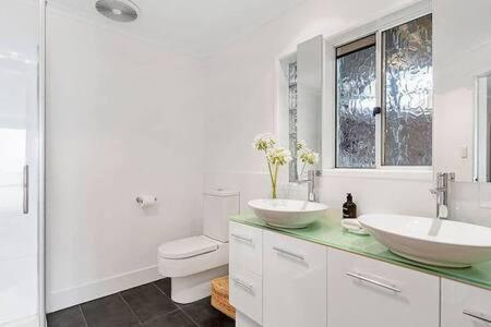 霍巴特Hidden Bay Retreat-5 Bed- 15min to Hobart的白色的浴室设有2个盥洗盆和1个卫生间。