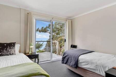 霍巴特Hidden Bay Retreat-5 Bed- 15min to Hobart的一间卧室配有一张床,享有海景