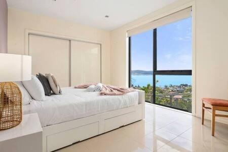 霍巴特The View Sandy Bay 5 bedroom的白色卧室设有大窗户和一张床