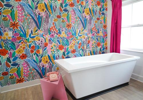 BellmeadIce Cream Retreat at Casa Kumwesu的浴室设有白色浴缸和花卉壁纸
