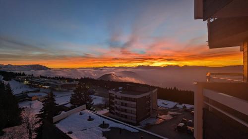 尚鲁斯Chamrousse 1750 Roche Béranger 50m2 4-6pers Vue panoramique的享有市景和山景的日落美景