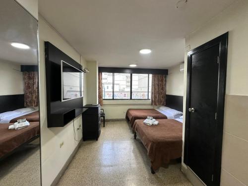 瓜亚基尔Residencia Terreros的酒店客房设有两张床和电视。