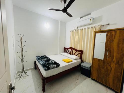 ThanniyamFurnished 2 BHK Family Apartments near Triprayar Shree Rama Temple - Beevees Homes Thriprayar的一间带一张床和吊扇的小卧室