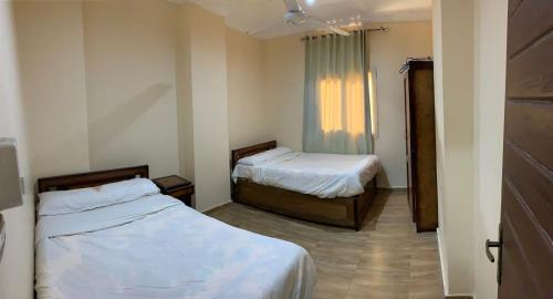 马特鲁港Almanara Hotel Marsa Matrouh的客房设有两张床和窗户。