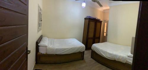 马特鲁港Almanara Hotel Marsa Matrouh的小房间设有两张床和一个衣柜