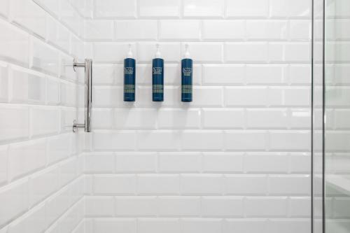 基洛纳基洛纳机场福朋喜来登酒店的浴室设有2瓶蓝色的瓶装水和淋浴。
