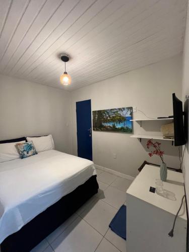 费尔南多 - 迪诺罗尼亚Coral azul Noronha的一间卧室配有一张床、一张书桌和一台电视。