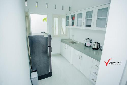 BorupaneVirooz Residence Rathmalana 2 Bedroom Apartment的厨房配有白色橱柜和不锈钢冰箱
