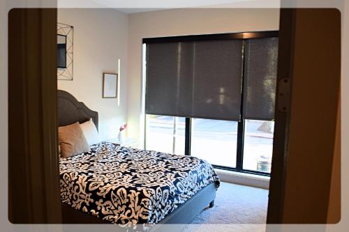 亚特兰大Atlanta at The Interlock Lux Escape的一间卧室设有一张床和一个大窗户
