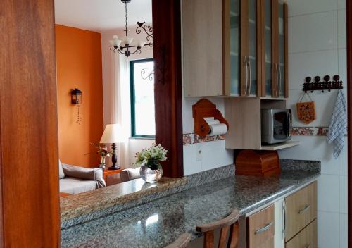 佩尼亚Casa de Praia Penha, Beto Carrero, 500m da Praia da Armação的厨房设有橙色墙壁和台面