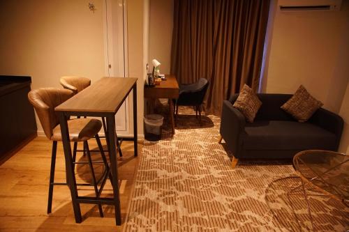 吉隆坡Dê MOCCIS Boutique Hotel的客厅配有桌子和沙发