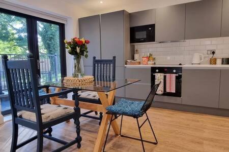 伦敦Beautiful Apartment Overlooking a Garden的厨房配有玻璃桌和两把椅子