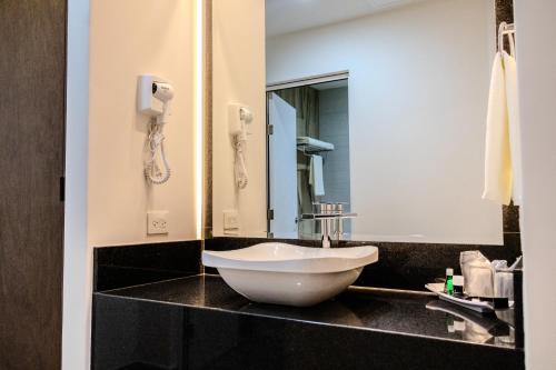 纳沃华Hotel Gran Avenida, Navojoa的一个带白色碗水槽的柜台浴室