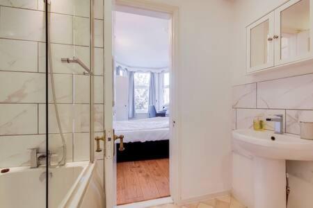 伦敦Spacious Apartment In The Heart Of Ealing Broadway的一间带水槽、卫生间和淋浴的浴室