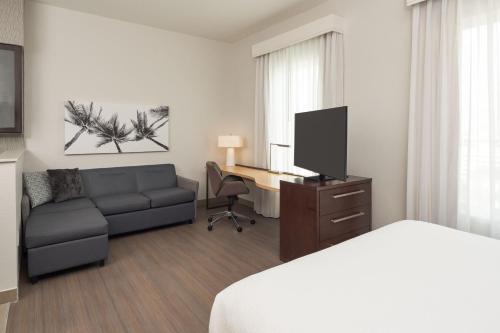西棕榈滩Residence Inn by Marriott West Palm Beach Downtown的酒店客房配有一张沙发和一张书桌