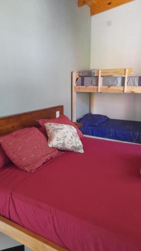 伊瓜苏港Puesta del Sol Apart的一间卧室配有一张红色床罩的床
