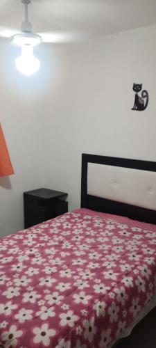 拉蓬塔La Candelaria的一间卧室配有一张带红色毯子和鲜花的床