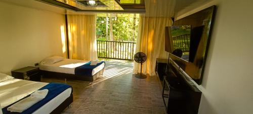 金巴亚Hotel Campestre Nogal de Cafetal的酒店客房设有两张床和一个阳台。