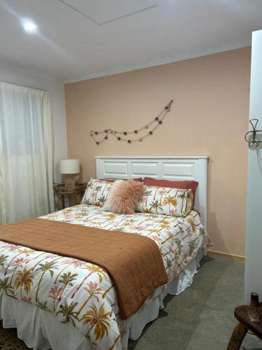 Parua BayJordan Place的卧室配有一张带毯子的床和墙上的风筝。
