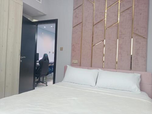 迪拜Mag5的卧室配有白色的床和书桌