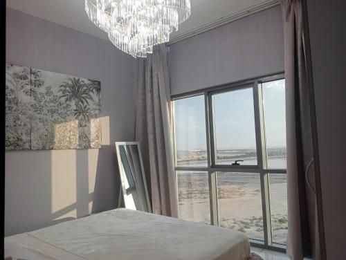 迪拜Mag5的一间卧室设有大窗户和吊灯