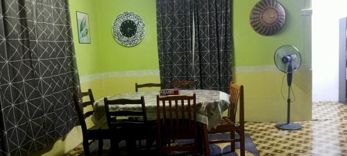 斯利姆河Kurnia Homestay的用餐室设有桌椅和绿色墙壁