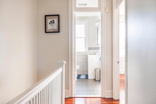 华盛顿Charming 4 Bedroom House!1 Mile from Capitol Hill!的一条带白色墙壁的走廊和一条带楼梯的白色楼梯