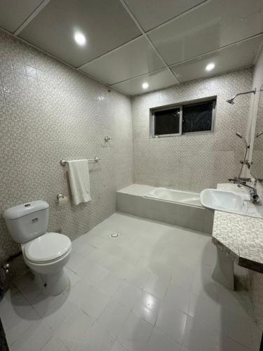 伊斯兰堡Aleph Islamabad Guest House的浴室配有卫生间、浴缸和水槽。