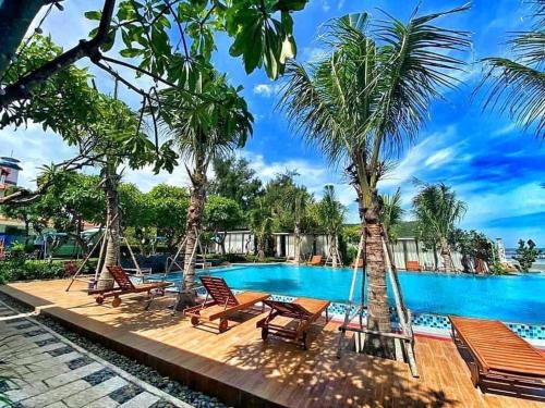 隆海安和公寓酒店的度假村的游泳池,配有椅子和棕榈树