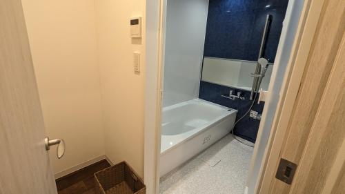 宫古岛MAHHO TERRACE MIYAKO的带浴缸和白色浴缸的浴室