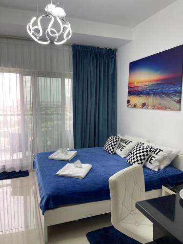 迪拜Great view, Dubai SportCity, parking included, nice Apartments的一间卧室配有蓝色的床和吊灯。