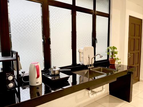 瓜拉丁加奴The Urban Lodge 1的厨房配有水槽和带窗户的柜台。