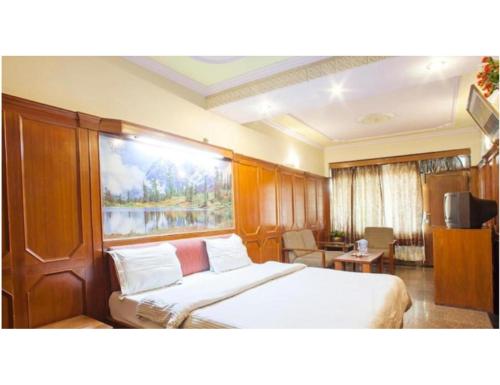 穆索里Hotel Valley View, Mussoorie的一间卧室设有一张床和一个大窗户
