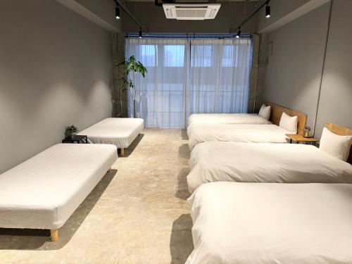 高松Hotel art rock的白色床单的房间里一排床