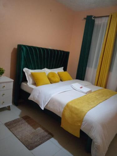 EmbuEmbu Paradise 1 bedroom AirBNB的一间卧室配有一张带黄色枕头的大床