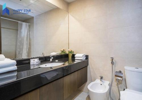 迪拜Luxurious 2BR Apartment near Palm Jumeirah的一间带水槽、卫生间和镜子的浴室