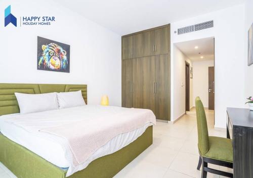 迪拜Luxurious 2BR Apartment near Palm Jumeirah的一间卧室配有一张床、一张桌子和一把椅子