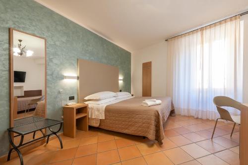 阿西西索雷酒店的酒店客房,配有床和镜子