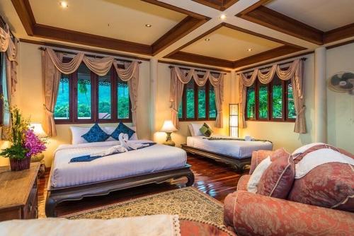 苏梅岛Entire 5 beds Pool Villa on hill side.的一间卧室设有两张床、一张沙发和窗户。