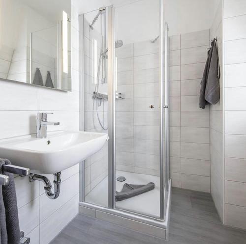 库克斯港Hotel Gasthof Zur Post的一间带玻璃淋浴和水槽的浴室