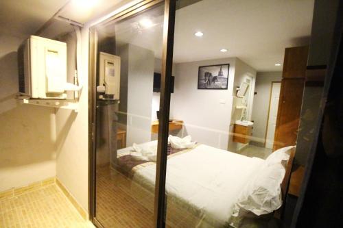 曼谷L Hotel的一间设有床铺和玻璃墙的房间