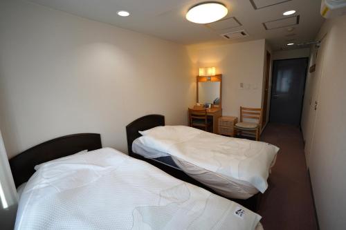 白马村The Hakuba Station Room的配有两张床铺的客房配有桌椅