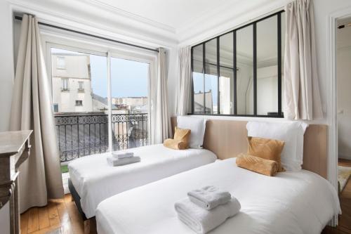 巴黎韦尔蒂公寓酒店的带大窗户的客房内的两张床